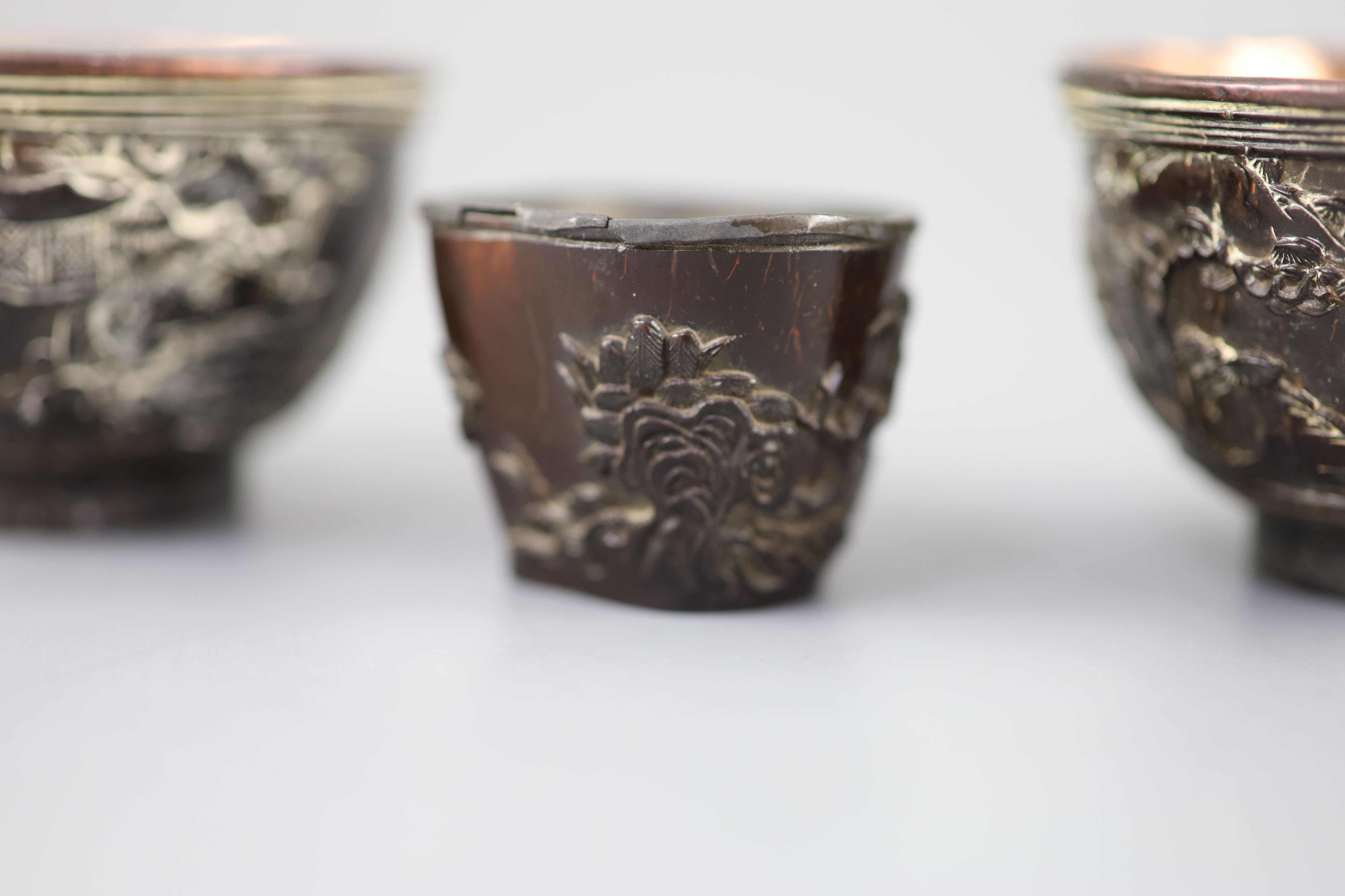 A pair of Chinese coconut landscape cups and a similar peach-shaped cup, 18th/19th century,